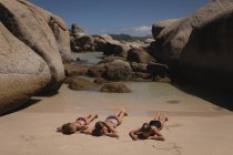 Irmãos relaxantes na praia em um dia ensolarado — Fotografia de Stock