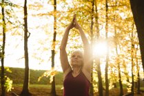 Seniorin praktiziert an einem sonnigen Tag Yoga im Park — Stockfoto