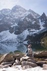 Vista trasera del excursionista femenino mirando la montaña cubierta de nieve - foto de stock