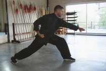 Kung fu lutador praticando artes marciais no estúdio de fitness . — Fotografia de Stock