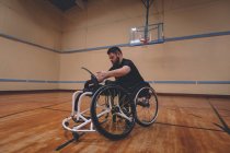 Homem com deficiência que opera cadeira de rodas no tribunal — Fotografia de Stock