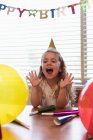 Menina feliz comemorando seu aniversário em casa — Fotografia de Stock
