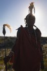 Портрет мужчины-масаи, стоящего в сельской местности в солнечный день — стоковое фото