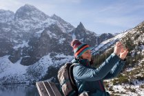Female hiker taking photo with mobile phone on a sunny day — Stock Photo