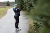 Donna incinta che utilizza il telefono cellulare nel parco — Foto stock