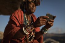 Uomo Maasai in abbigliamento tradizionale utilizzando il telefono cellulare — Foto stock