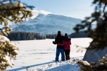 Coppia in piedi insieme nel paesaggio montano durante l'inverno . — Foto stock