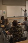 Lehrer unterrichtet Schüler auf Whiteboard im Klassenzimmer — Stockfoto