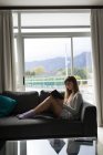 Жінка читає книгу у вітальні вдома — стокове фото
