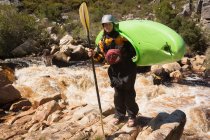 Mujer de pie con bote de kayak y remo por río . - foto de stock