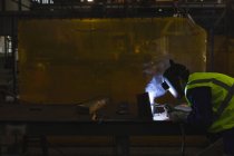 Schweißer repariert Schiffsteil in Werkstatt — Stockfoto