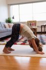 Nettes Mädchen macht Yoga im Wohnzimmer zu Hause — Stockfoto