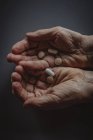 Крупный план пожилых женщин, держащих в руках таблетки — стоковое фото