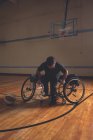 Jeune homme handicapé en fauteuil roulant au terrain de basketball — Photo de stock