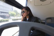 Thoughtful asian teenage girl travelling in the bus — Stock Photo