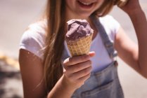 Primo piano della ragazza che tiene il cono del waffle con il gelato all'aperto . — Foto stock