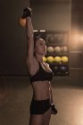 Fit woman exercising with kettlebell in the studio — Stock Photo