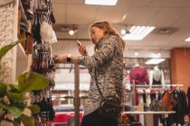 Bella ragazza utilizzando il telefono cellulare durante lo shopping nel centro commerciale — Foto stock