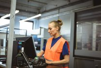Mulher caucasiana trabalhando no computador na fábrica — Fotografia de Stock