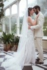 Mariée romantique et marié embrassant dans le balcon à la maison — Photo de stock