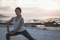 Woman exercising in the beach during sunset — Stock Photo