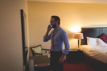 Бизнесмен разговаривает по мобильному телефону в отеле — стоковое фото