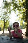 Menina bonito segurando varinha de bolha no parque — Fotografia de Stock