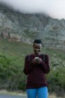 Молода жінка використовує мобільний в сільській місцевості — стокове фото