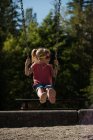 Мила дівчина грає на гойдалках в парку — стокове фото