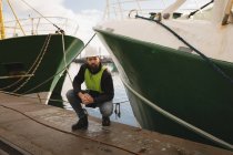 Portrait of dock worker posing near ship at port — Stock Photo