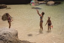 Geschwister spielen mit Ball im Meer am Strand — Stockfoto
