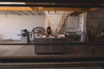 Женщина-ремесленница, работающая с чертежами стола в интерьере мастерской . — стоковое фото