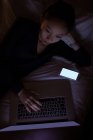Mulher usando laptop na cama no hotel — Fotografia de Stock
