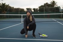 Femme réfléchie dans le court de tennis — Photo de stock