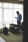 Бизнесмен, пользующийся мобильным телефоном в номере отеля — стоковое фото
