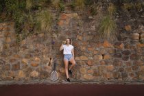 Уставшая женщина пьет воду на теннисном корте — стоковое фото