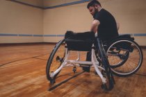 Disabled man operating wheelchair in the court — Stock Photo