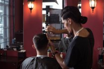Homme se faire couper les cheveux avec des ciseaux au salon de coiffure — Photo de stock