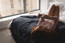 Frau nutzt digitales Tablet zu Hause im Schlafzimmer — Stockfoto