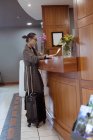 Жінка читає документ на рецепції готелю — стокове фото