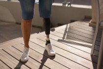 Ausgeschnittene Ansicht einer Frau mit Beinprothese, die zu Hause auf dem Balkon steht. — Stockfoto