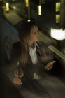 Empresária desviando o olhar enquanto bebe champanhe no lobby — Fotografia de Stock