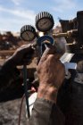 Крупним планом працівник, який керує газовим циліндром на металобрухті — стокове фото