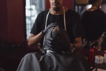 Barbier essuyant le visage des clients avec une serviette au salon de coiffure — Photo de stock