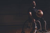 Pensativo hombre discapacitado practicando baloncesto en la cancha - foto de stock