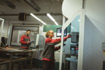 Dos trabajadores que comprueban la máquina en fábrica - foto de stock