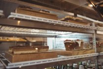 Variété de pâtisseries dans les étagères d'exposition au café — Photo de stock