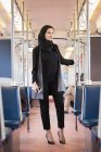 Mujer pensativa en hijab viajando en tren - foto de stock