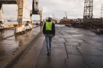 Vista posteriore del lavoratore portuale che cammina nel cantiere navale — Foto stock