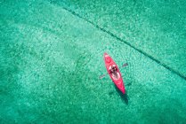 Kayaker kayak in acque turchesi poco profonde in una giornata di sole — Foto stock
